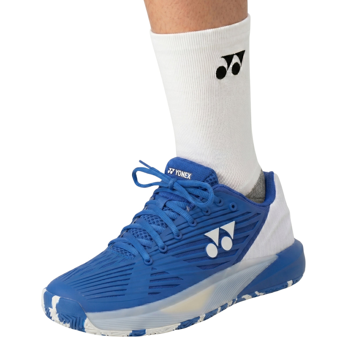 Person wearing a sock with a Yonex tennis hoe