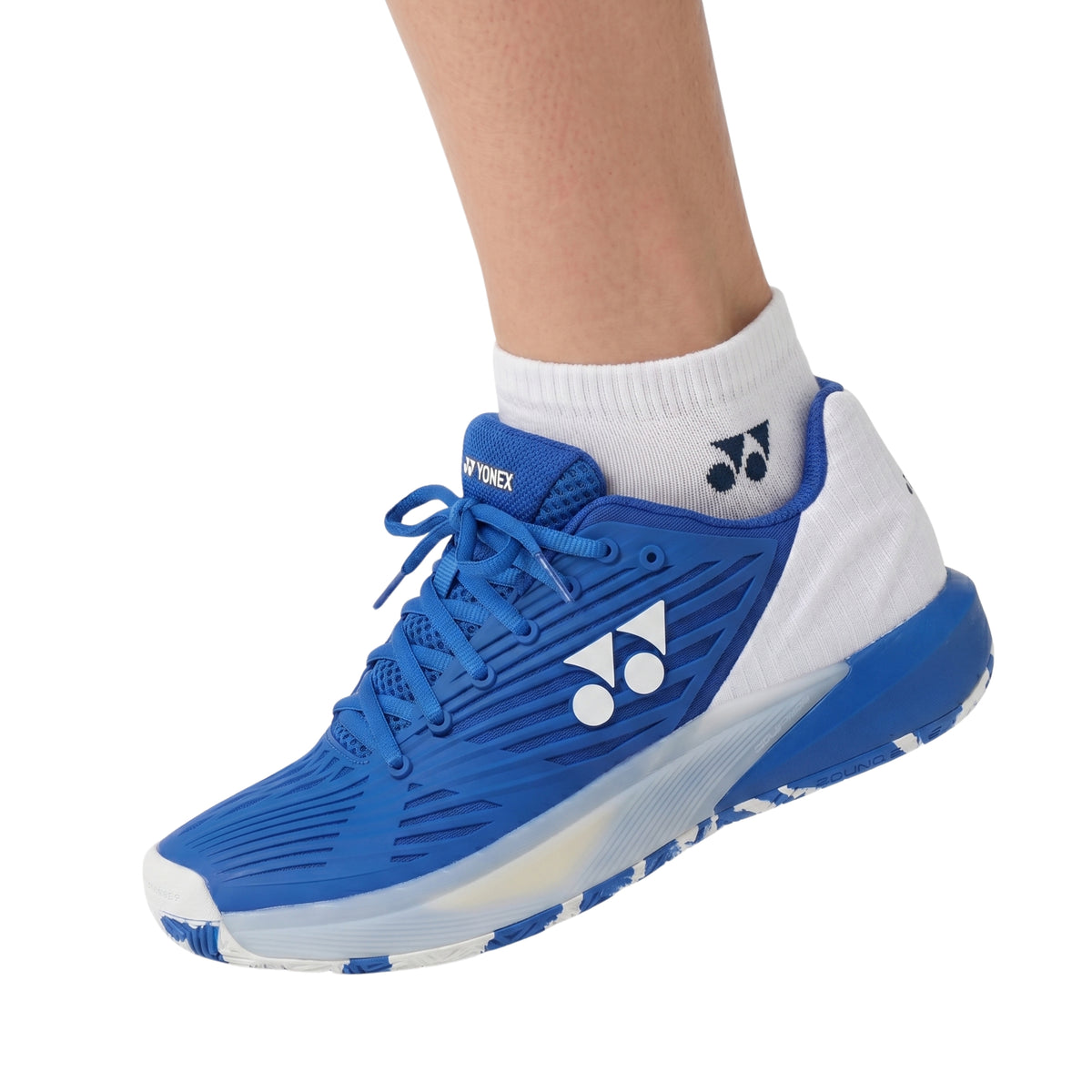 Blue athletic shoe with white sole on a white background