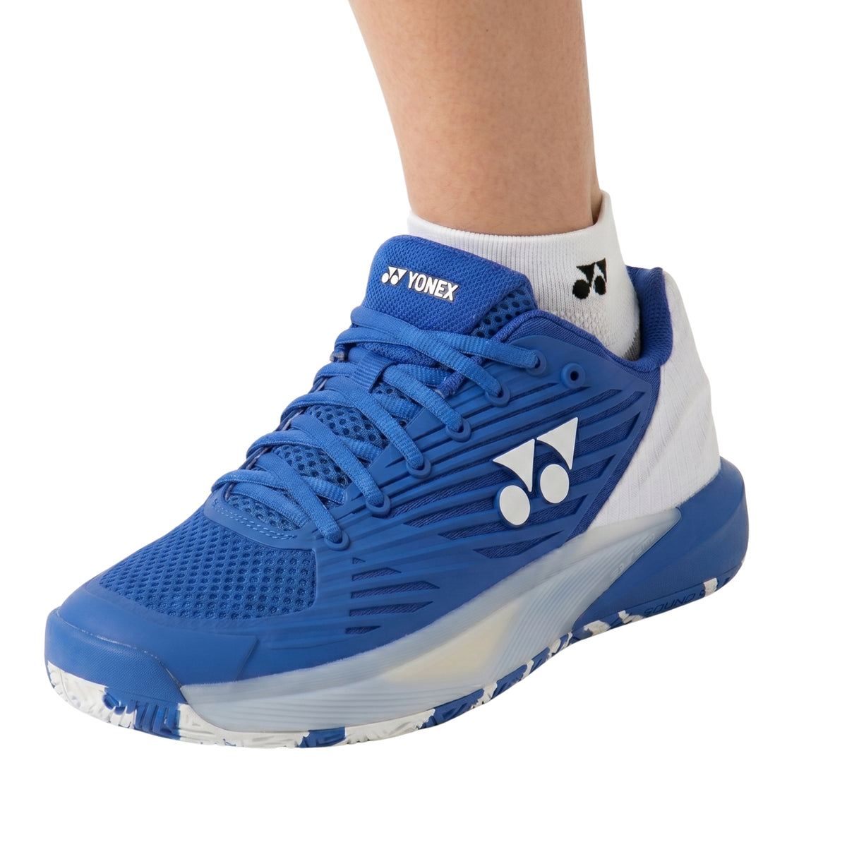 White Yonex ankle sock with Yonex shoe on a white background