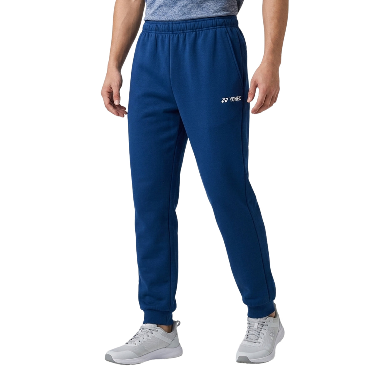 Person wearing blue Yonex sweatpants on a white background
