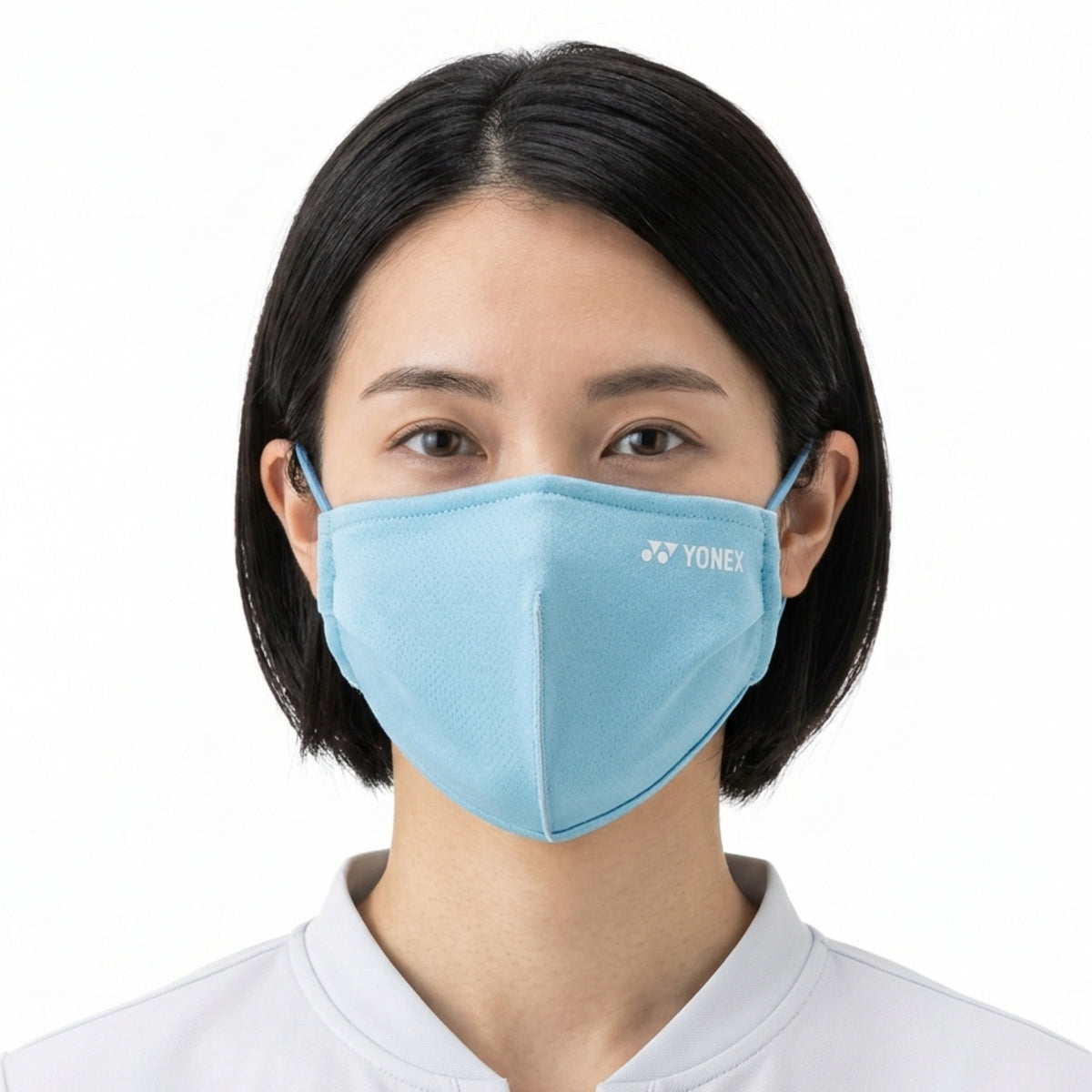 Person wearing a light blue face mask with Yonex logo on a white background