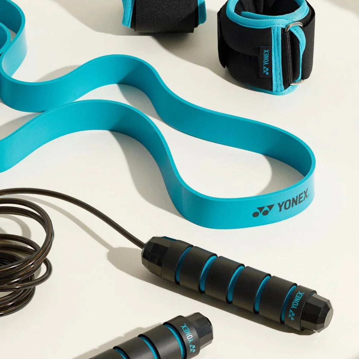 Yonex resistance band and jump rope on a white background