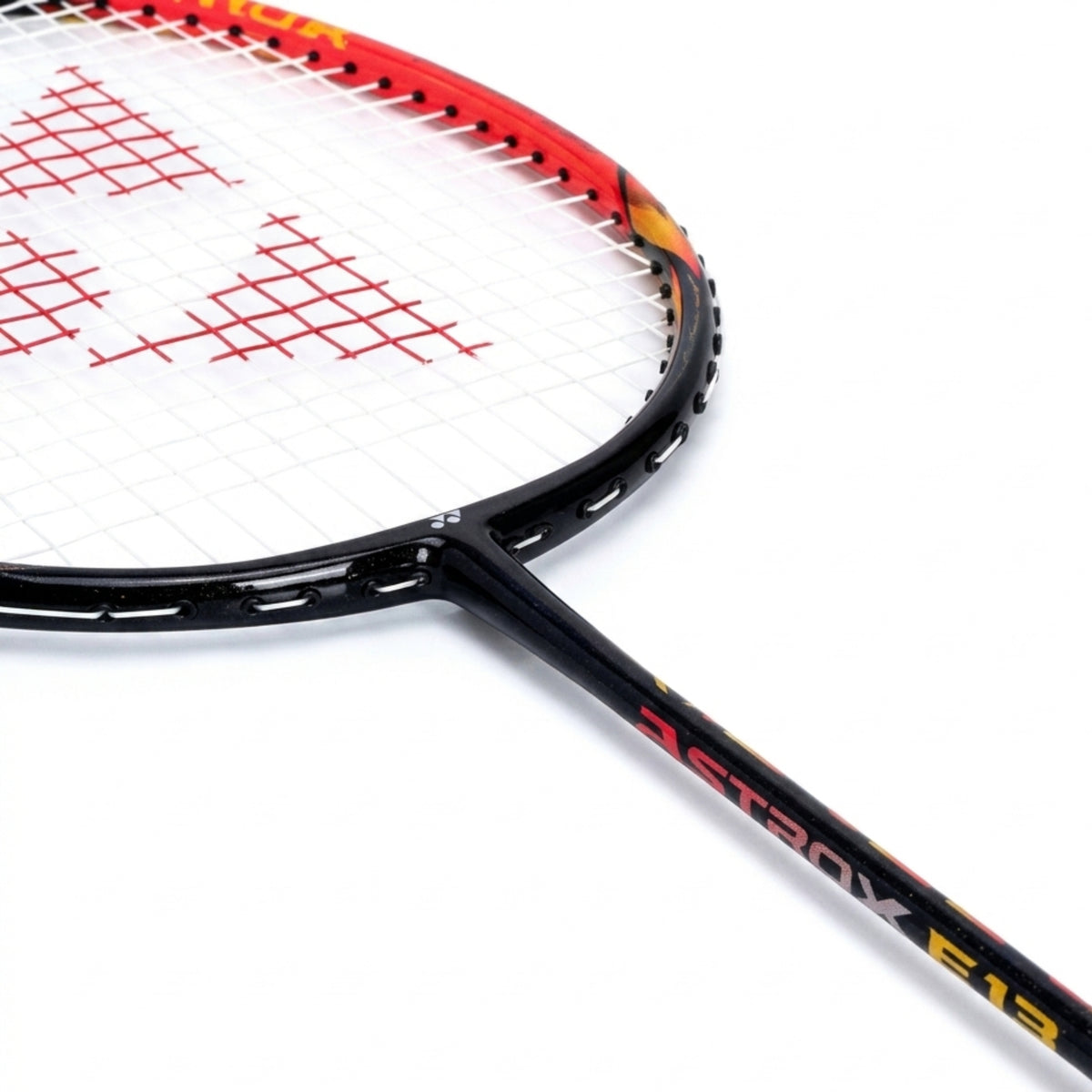 Close-up of a badminton racket with red strings on a white background