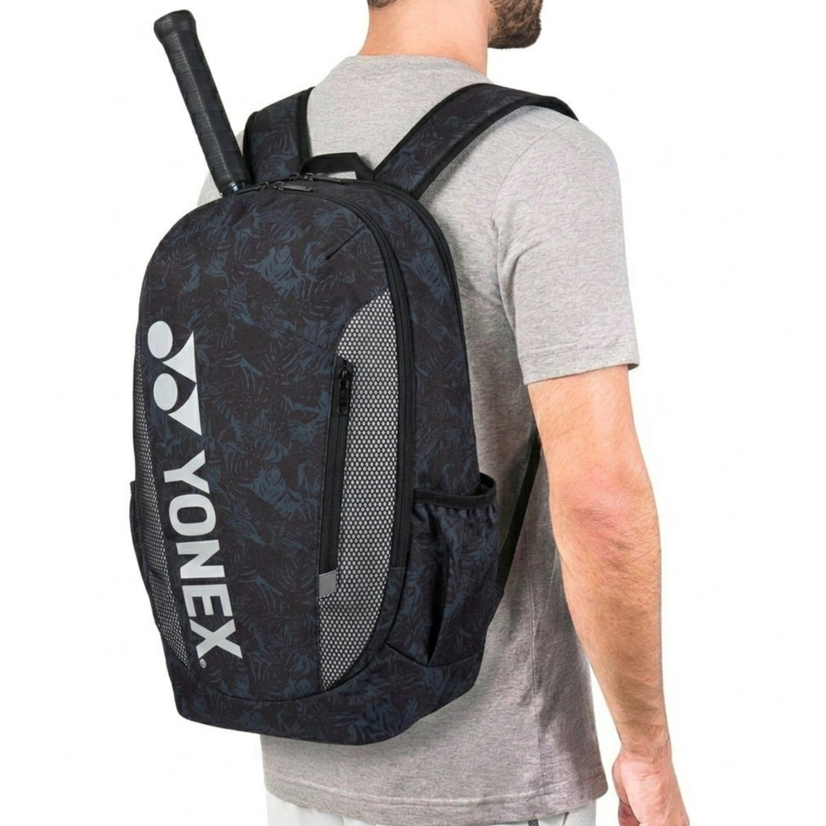 Person wearing a Yonex backpack with a racket on a white background