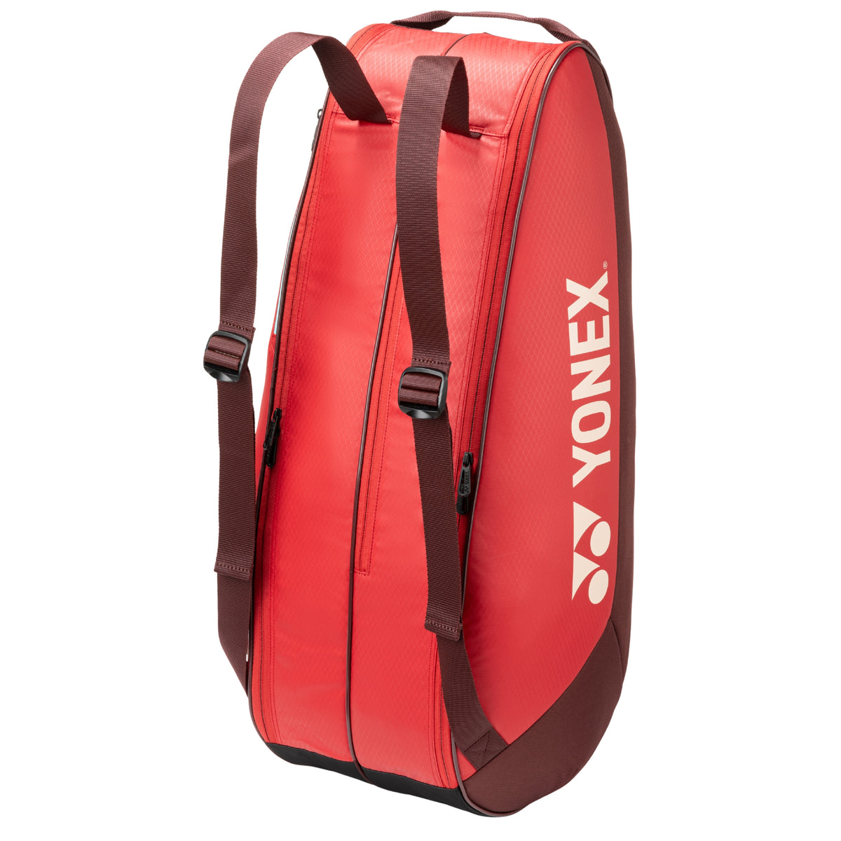 Red tennis bag with brown straps and Yonex logo on a white background