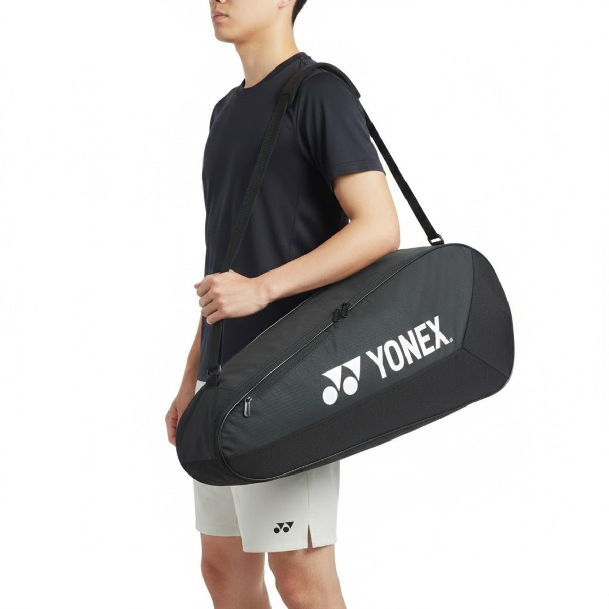 Person holding a Yonex racket bag on a white background