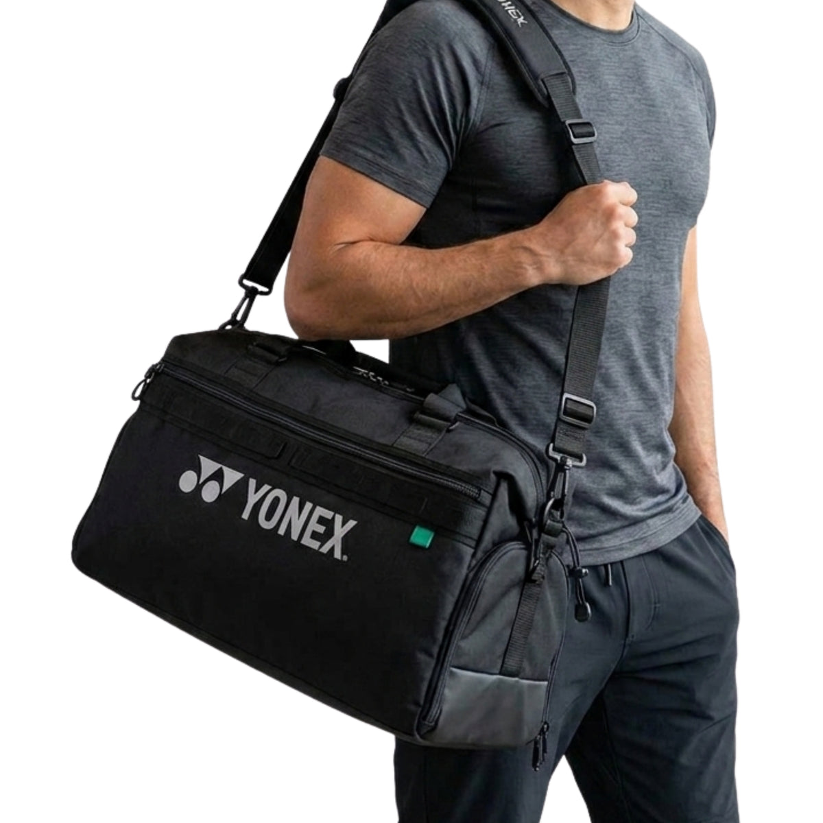 Person carrying a black Yonex bag on a white background