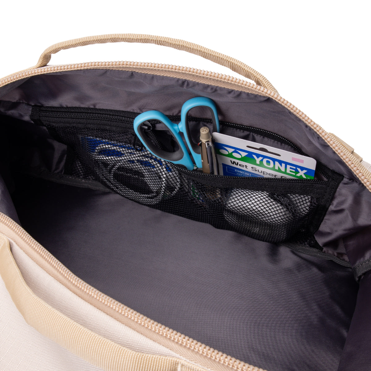 Open bag with Yonex tennis racket and blue scissors inside