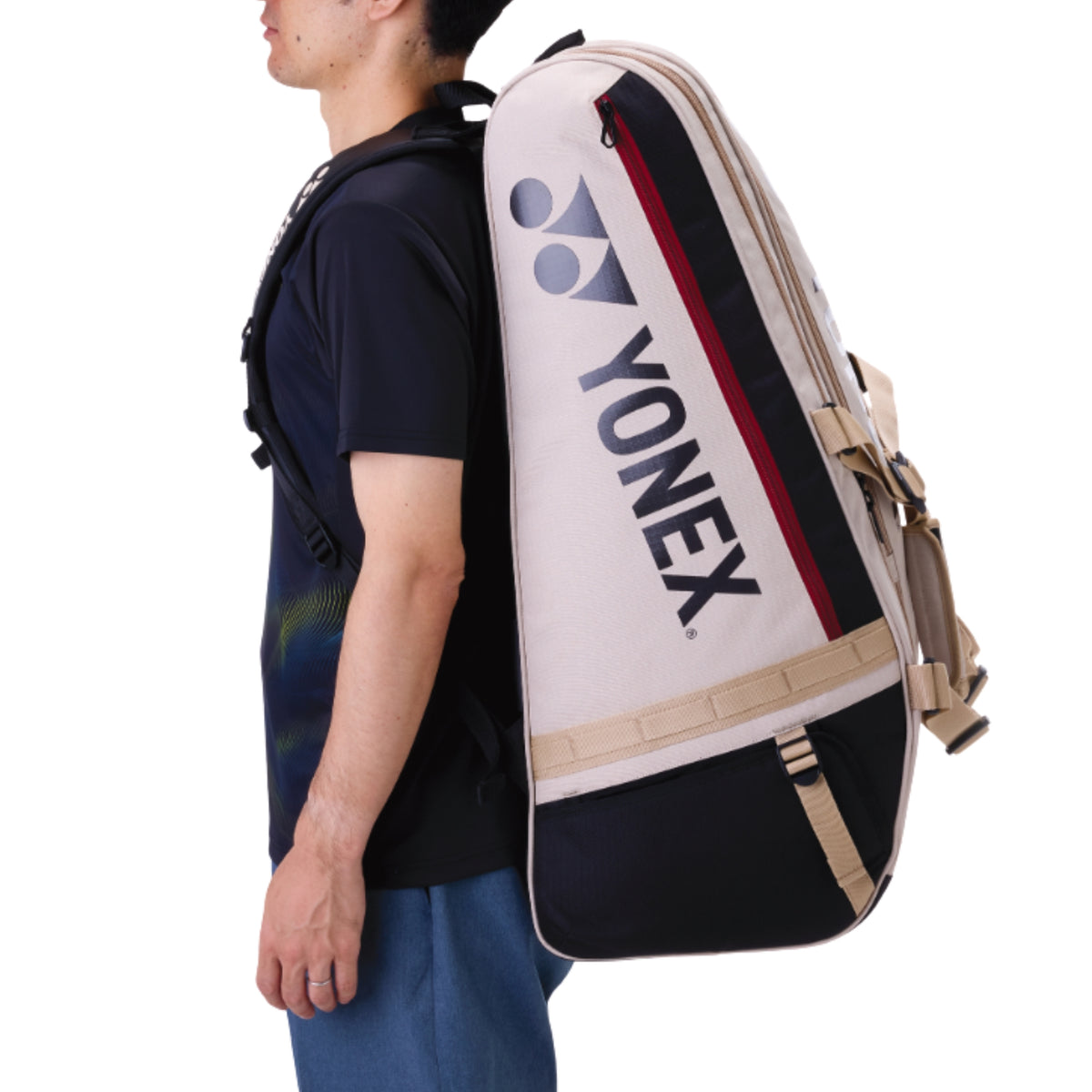 Person carrying a Yonex tennis bag on their back against a white background