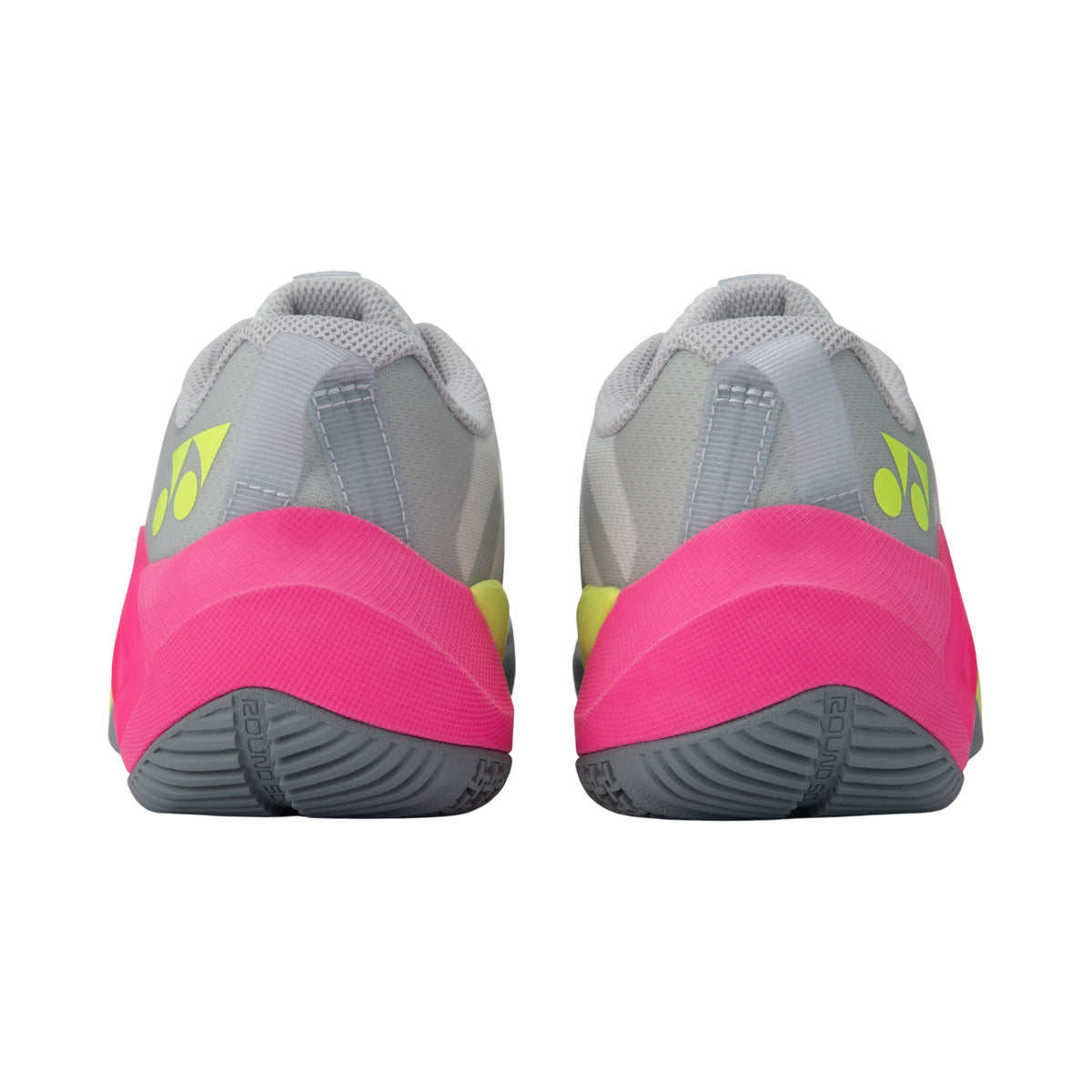 Pair of gray and pink Yonex tennis shoes with green accents on a white background