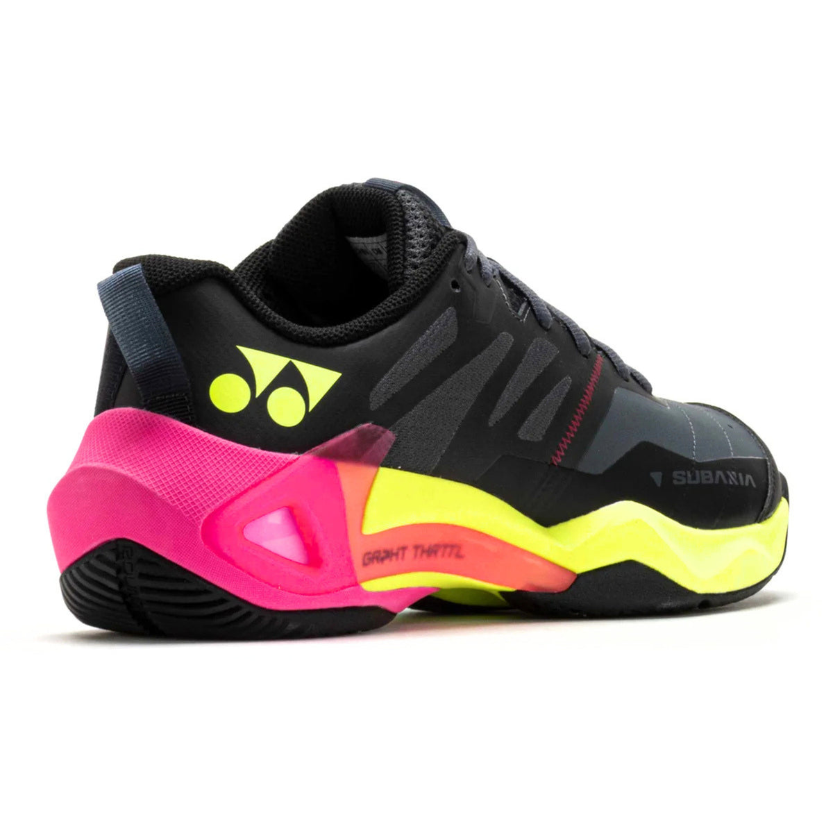 Black Yonex tennis shoe with pink and yellow sole on a white background