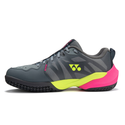 Gray Yonex tennis shoe with pink and yellow sole on a white background