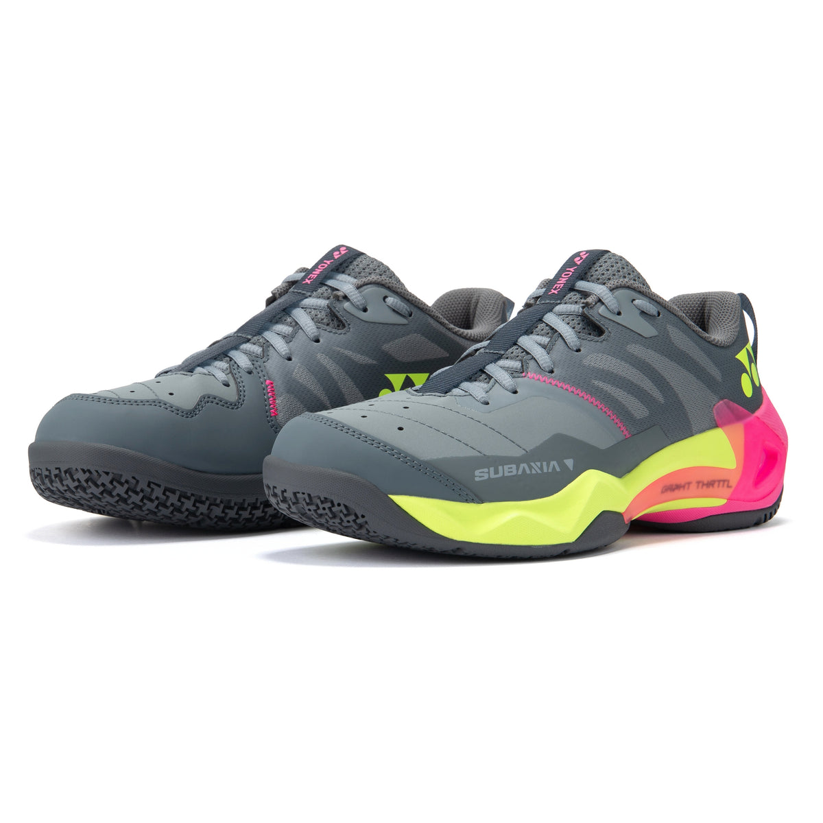 Gray Yonex tennis shoes with pink and yellow sole on a white background