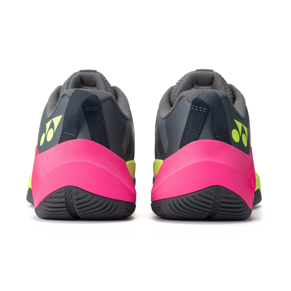 Pair of gray and pink Yonex tennis shoes with brand logo on a white background