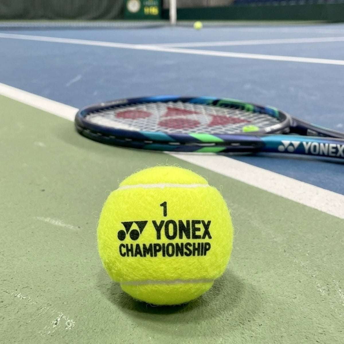 Yonex tennis ball and racket on a tennis court