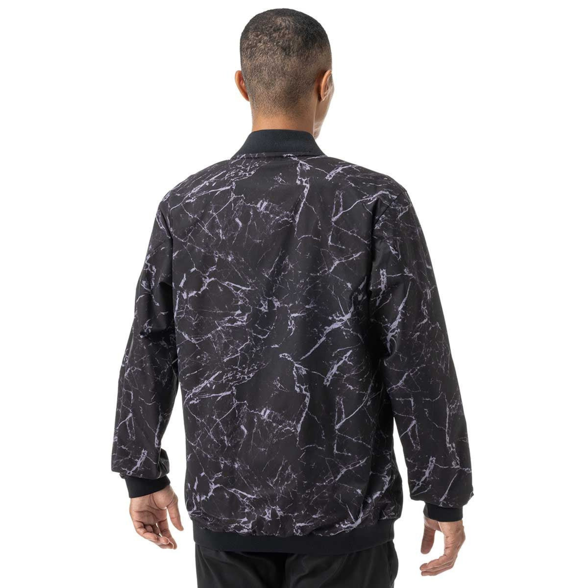 Person wearing a black and white patterned jacket on a white background