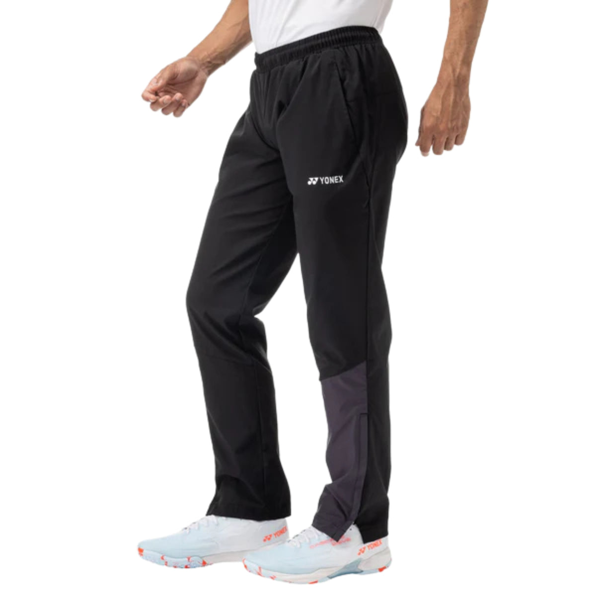 Person wearing black Yonex sports pants on a white background