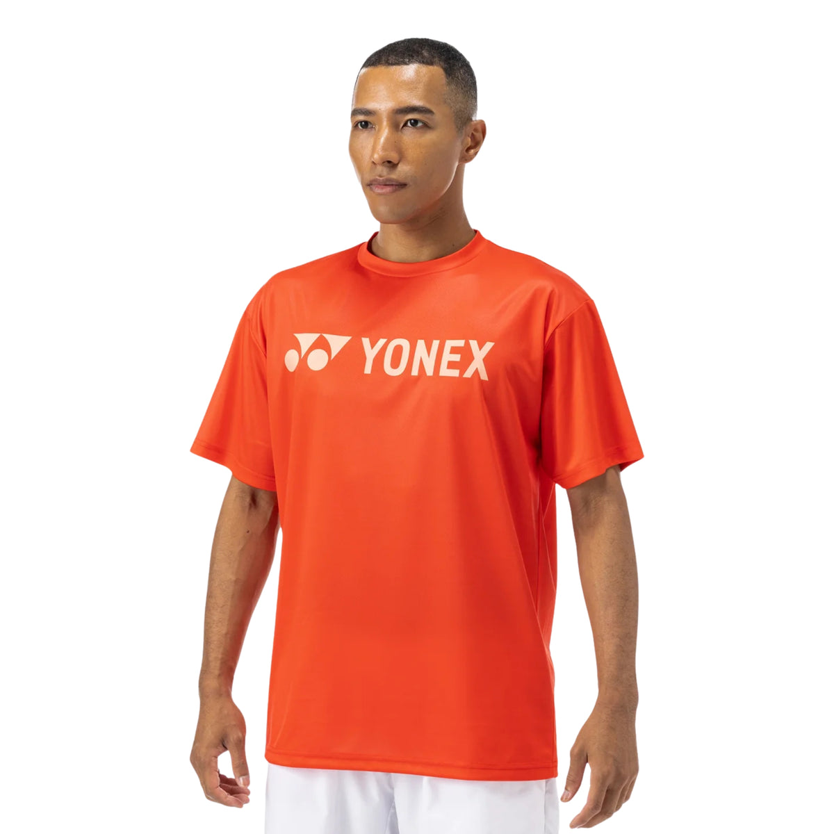 Man wearing an orange Yonex t-shirt on a white background